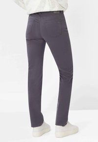 Skræddersyede grå jeans med en slank pasform, med to baglommer, blødt bomuldsstof og en glat tekstur, kombineret med hvide sneakers.