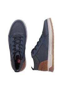 Baskets montantes navy avec accents marron, présentant un panneau en tissu texturé, une semelle en caoutchouc et des lacets. Coutures détaillées visibles.