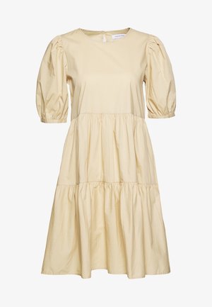 Robe en coton jaune clair avec des manches courtes bouffantes, un col rond et une jupe à étages fluide. Présente une texture subtile et une fermeture par cléhole au dos.