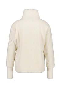 Vit fleece-pullover med hög krage, texturerad yta och långa ärmar. Har en diskret logotyp på vänster ärm.