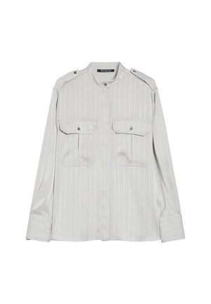 Lichtgrijs T-shirt met lange mouwen, voorzien van dunne verticale strepen, twee voorste knoopzakken met flap en knoopbare schouderepauletten.