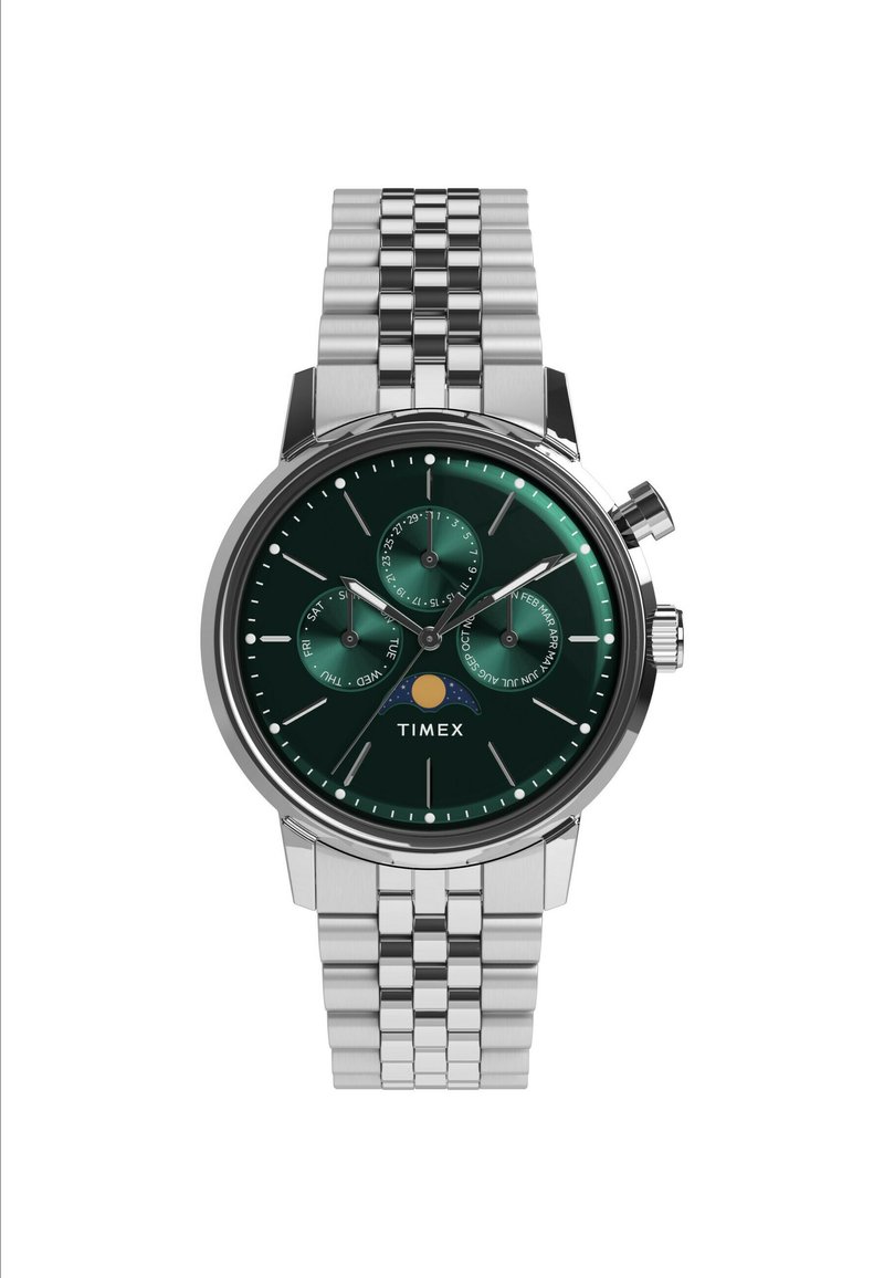 Montre en acier inoxydable argenté avec un cadran vert, trois sous-cadrans et un indicateur de date. Elle possède un bracelet à maillons texturé. Marque : Timex.