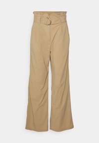 Beige weit geschnittene Hose mit hoher Taille, ausgestattet mit einem Frontfalten und einem silbernen Ringgürtel. Glatte Textur und maßgeschneiderter Schnitt.
