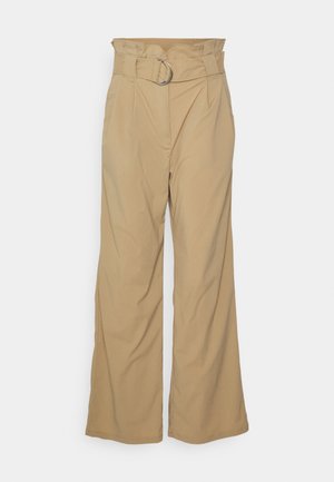 Pantaloni beige a gamba larga con vita alta, caratterizzati da una piega frontale e una cintura con anello in metallo argentato. Tessuto liscio e design su misura.