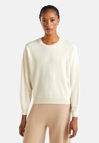 Maglione a collo tondo in morbido tessuto crema, con maniche lunghe, polsini e orlo a costine, dalla vestibilità rilassata e texture liscia.