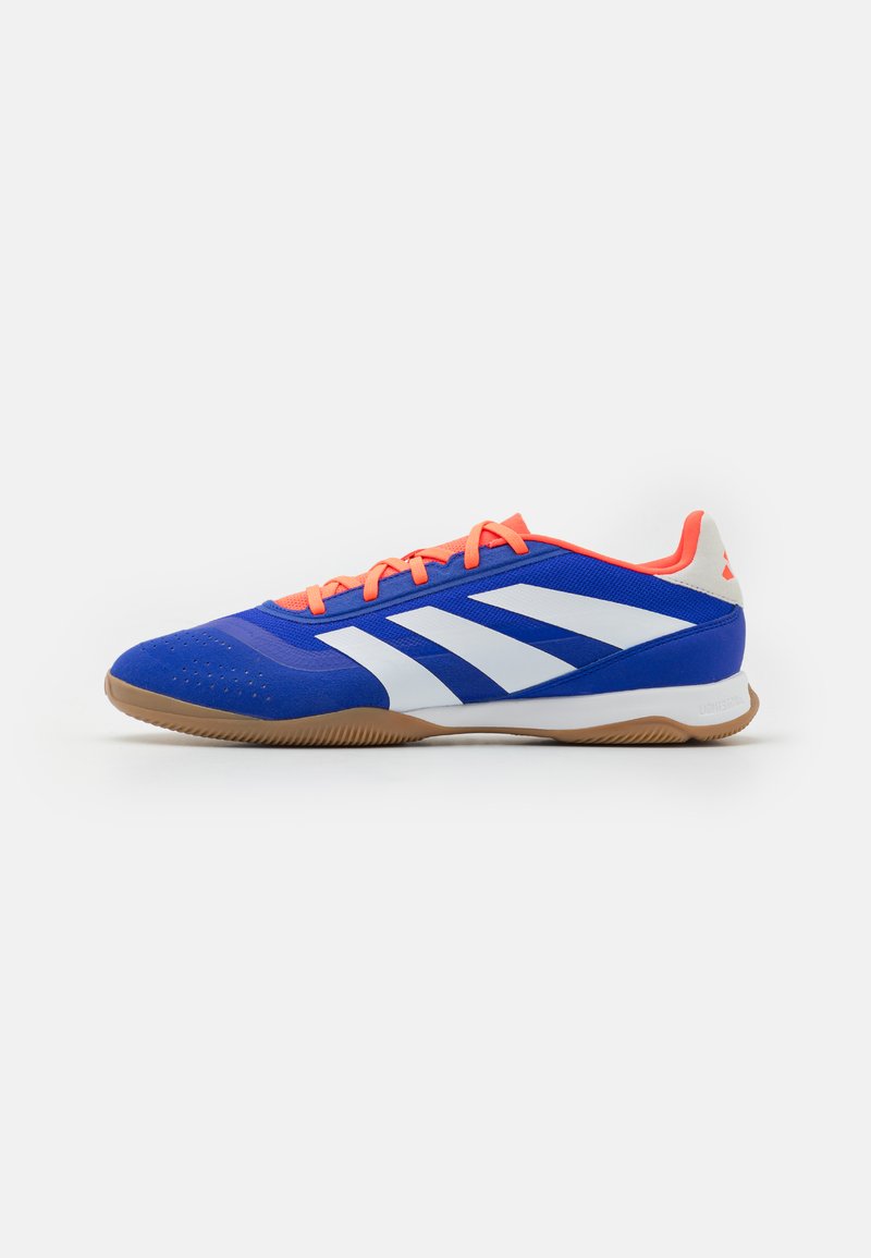 Zapatilla deportiva azul con rayas blancas, cordones naranjas y suela de goma. Presenta una textura suave y detalles perforados en la puntera.