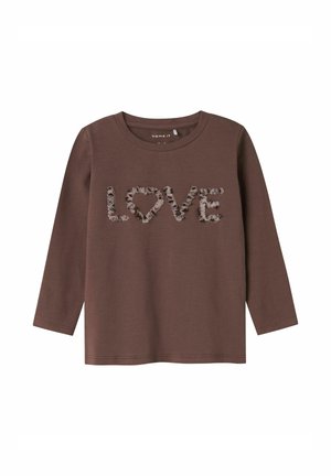 Brązowa koszula z długim rękawem z teksturowanym napisem "LOVE" oraz wzorem serca w falbaniastym jasnobrązowym akcentem. Miękka tkanina, prosty dekolt typu crew.