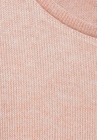 Helles rosa gestricktes Gewebe mit einer weichen Textur, das ein dezentes Muster zeigt. Der Ausschnitt ist weit und mit einem gerippten Saum abgeschlossen.