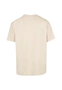Beige cotton t-shirt with short sleeves, crew neck, and a relaxed fit. Smooth texture, plain design, and no visible accents or patterns.