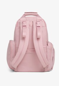 Ροζ σακίδιο φτιαγμένο από ύφασμα με επενδεδυμένα λουριά ώμου, μπροστινή τσέπη με φερμουάρ, πλευρικές τσέπες και λαβή στην κορυφή. Απλός, στρογγυλός σχεδιασμός χωρίς ορατά μοτίβα.