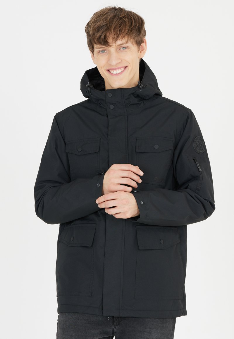 Sort parka jakke med lynlås og trykknaplukninger, justerbar hætte, fire frontlommer og et logo-patch på venstre ærme.