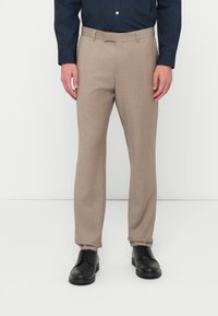 Μπεζ tailored παντελόνι με λεία υφή, σχέδιο ίσιας γραμμής και θηλιές ζώνης, σε συνδυασμό με μαύρα παπούτσια και ναυτικό πουκαμίσσ.