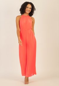Mono largo con cuello halter plisado en un vibrante color coral, que presenta una cintura ajustada y bolsillos, con piernas largas y fluidas y una tela ligera.