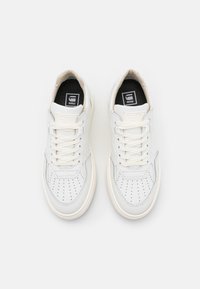 Weiße Leder-Sneaker mit durchbrochenen Details, kontrastierenden grauen Akzenten, flachen Schnürsenkeln und einer gepolsterten Sohle für Komfort.