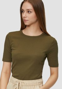 Olijfgroen t-shirt met korte mouwen van gladde stof met een ronde halslijn, gecombineerd met lichtbeige, elastische broek met tailleband.