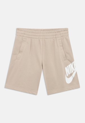 Beige treningsshorts laget av mykt stoff, med elastisk midjebånd, to sidelommer og en stor hvit Nike-logo på høyre ben.