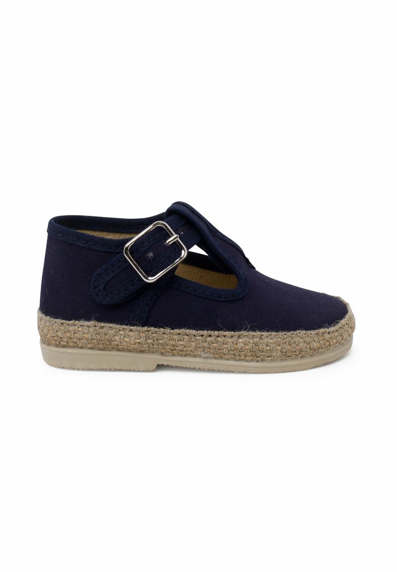 Navy fabric shoe with a round toe, braided jute sole, and a side strap featuring a metallic buckle. Flat, structured design.