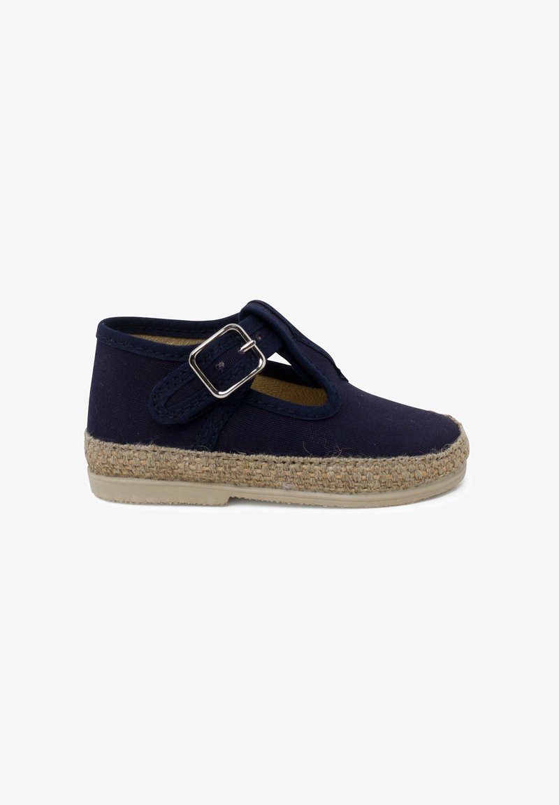 Navy fabric shoe with a round toe, braided jute sole, and a side strap featuring a metallic buckle. Flat, structured design.