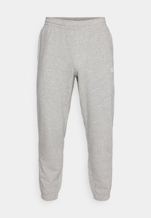Grå sweatpants med en tætsiddende pasform, elastisk talje og manchetter. Blødt stof med subtil tekstur. Har et lille hvidt logo på siden.