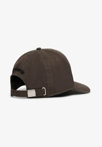 Gorra de béisbol de tela marrón con visera curvada, cierre ajustable de metal plateado en la parte trasera y texto bordado tonal en la parte posterior.