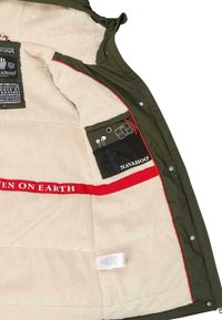 Olijfgroene jacket met een zachte, crèmekleurige fleece voering. Voorzien van rode accenten en binnenzakken voor opslag. Gelaagde buitenkant met drukknoopsluiting.
