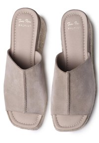 Infradito beige in suede con design aperto, texture morbida e dettagli cuciti sulla suola. Il tacco a cuneo leggero aumenta il comfort.