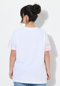 Hvid bomulds t-shirt med korte ærmer, prydet med pink striber på ærmerne. Let løs pasform, rund halsudskæring og en blød tekstur.