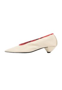 Zapatos de charol crema con punta afilada, forro texturizado rojo y un talón escultórico único. Superficie suave con un brillo sutil.