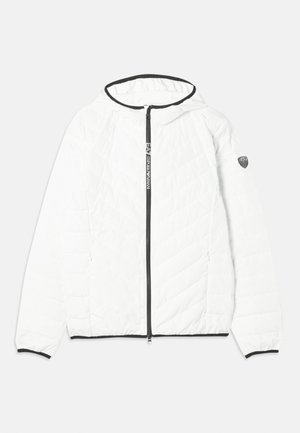 Valge tikandiga jakk kapuutsiga, musta tõmblukuga ja kontrastsete mustade ääristustega alläärmisel ja varrukatel. Varustus logodetailiga varrukal.