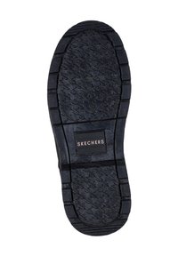 Suela de zapato de goma negra con un patrón de espina de pescado texturizado. Presenta un parche rectangular con el logo "SKECHERS" cerca del talón.