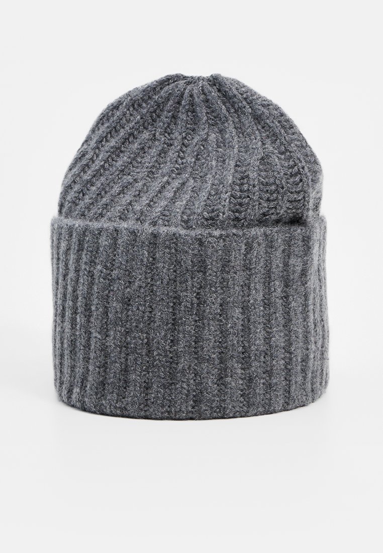 Szara dziana czapka beanie wykonana z grubego włóczki; charakteryzuje się ryflowaną fakturą i podwiniętym mankietem. Góra jest lekko zebrana, tworząc zaokrąglony kształt.