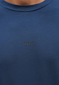 Μπλε ναυτικό t-shirt από �βαμβακερό μείγμα ύφασμα, με στρογγυλή λαιμόκοψη και διακριτικό ανάγλυφο λογότυπο "BOSS" στο στήθος.