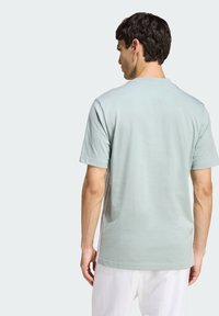 Světle zelené tričko s krátkým rukávem vyrobené z bavlny, s kulatým výstřihem a hladkou texturou s minimálním švem.