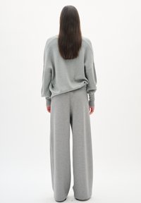 Gray oversized sweatshirt paired with wide-leg gray pants, both made of soft fabric, featuring a relaxed fit and minimal seam detailing.