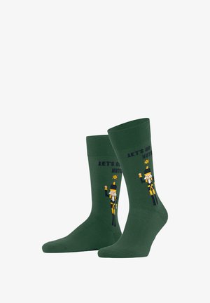 Grüne Baumwollsocken mit einem Nussknackerdesign, darüber der Text "LASS UNS VERRÜCKT WERDEN". Glatte Textur mit gerippten Bündchen.