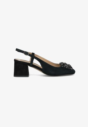 Zapato negro de ante tipo slingback con tacón cuadrado, punta afilada y adornos decorativos de cuentas negras en la parte superior. Correa de tobillo ajustable.