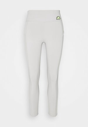 Vaaleanharmaat saumattomat legginsit, joissa on korkea vyötärö ja pieni vihreä ja musta puolikaarimainen logo vasemmalla puolella.