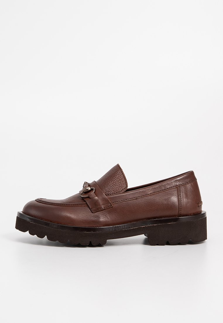 Mocasines de cuero marrón con un vampiro texturizado y una hebilla decorativa. Suela de goma gruesa con un patrón de tracción robusto para un mejor agarre.