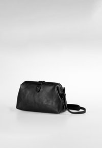 Borsa in pelle nera con texture liscia, chiusura con zip e tracolla removibile. Forma leggermente arrotondata con base piatta.