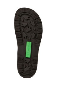 Suela de zapato de goma negra con un diseño texturizado, que presenta varios patrones de agarre y una etiqueta verde brillante que dice "El Naturalista."