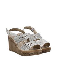 Sandalias de cuña con un upper metálico plateado que presenta intrincados diseños troquelados, plataforma color tostado y correa ajustable para el talón.
