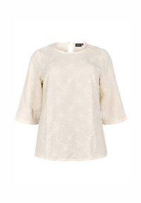 Blusa di colore crema con un motivo floreale testurizzato, scollo rotondo e maniche a lungo fino al gomito. Chiusura con zip sul retro, vestibilità leggermente rilassata.