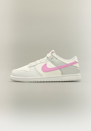 Baskets basses blanches avec des accents gris clair et un logo Nike Swoosh rose sur un fond neutre.