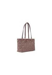 Sac fourre-tout en tissu marron avec motif floral en relief, poignées doubles et ferrures dorées. Forme rectangulaire, base plate pour plus de stabilité.