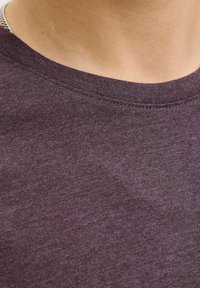 Short-sleeve purple t-shirt, soft texture, round neckline, minimal stitching details, set against a neutral background.