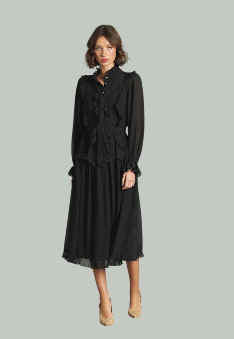 Vestido midi negro con volantes en capas, mangas largas y botones en la parte delantera. Tejido suave y transparente con un dobladillo plisado.