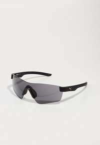 Lunettes de sport noires avec un grand verre foncé courbé, une monture en plastique élégante et un logo bien visible sur la branche.