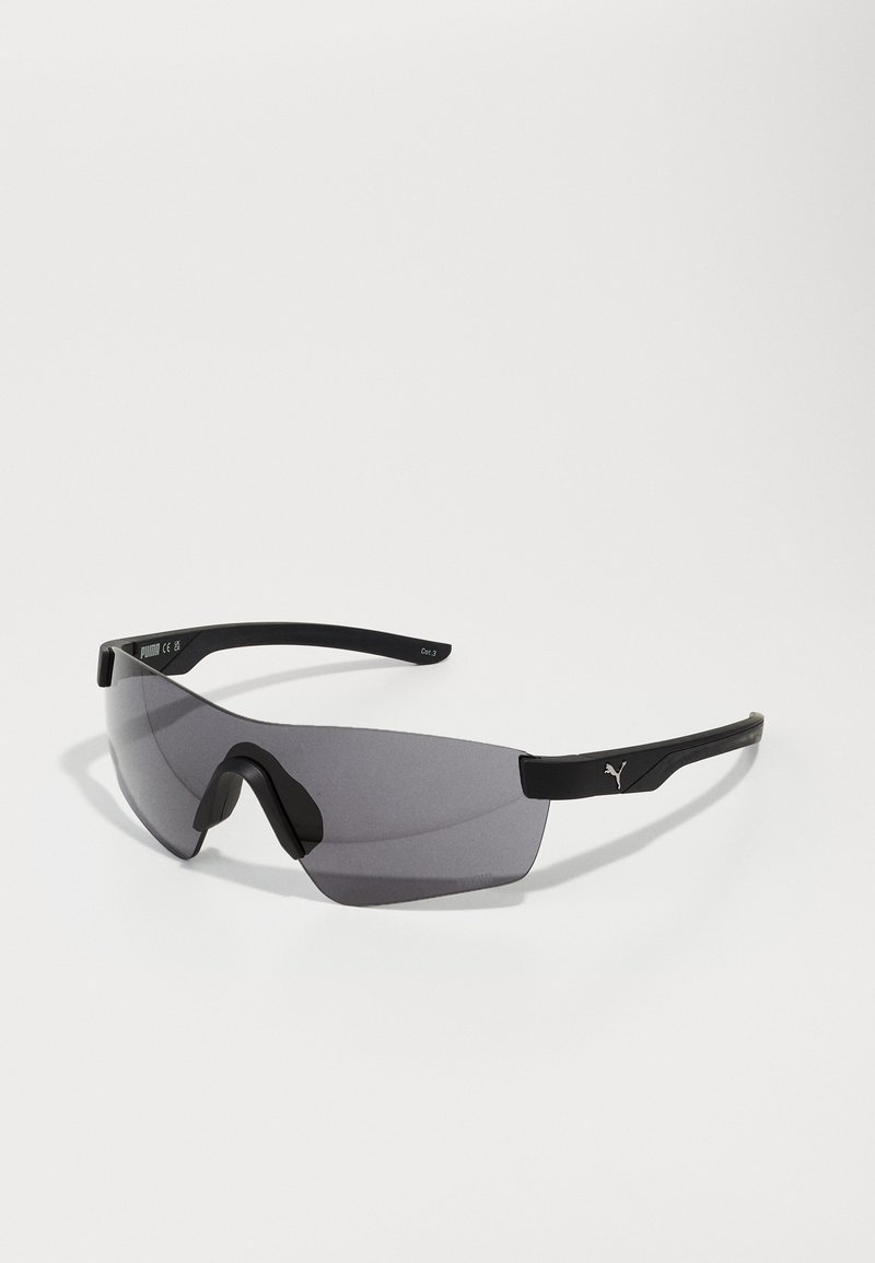 Lunettes de sport noires avec un grand verre foncé courbé, une monture en plastique élégante et un logo bien visible sur la branche.