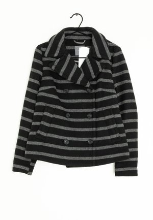 Zwart- en grijs gestreept, dubbelgeknoopt jack met brede kraag en zwarte knopen, getoond aan een hanger.