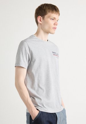 Gray cotton t-shirt with a crew neckline, short sleeves, and a small logo design in blue and red across the chest. Smooth texture.